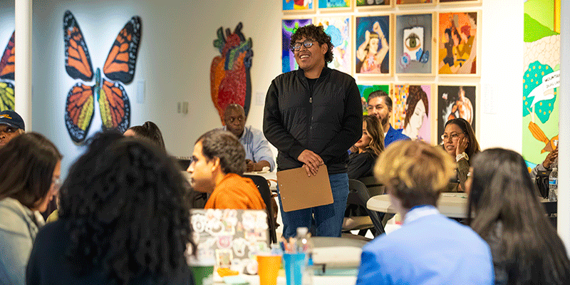 students listening to speaker at a table
